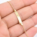 14K solid yellow gold baby ID Figaro chain bracelet held in hand