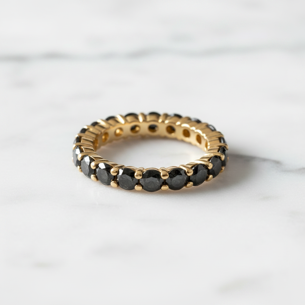 Black Diamond Eternity Ring in Yellow Gold on marble